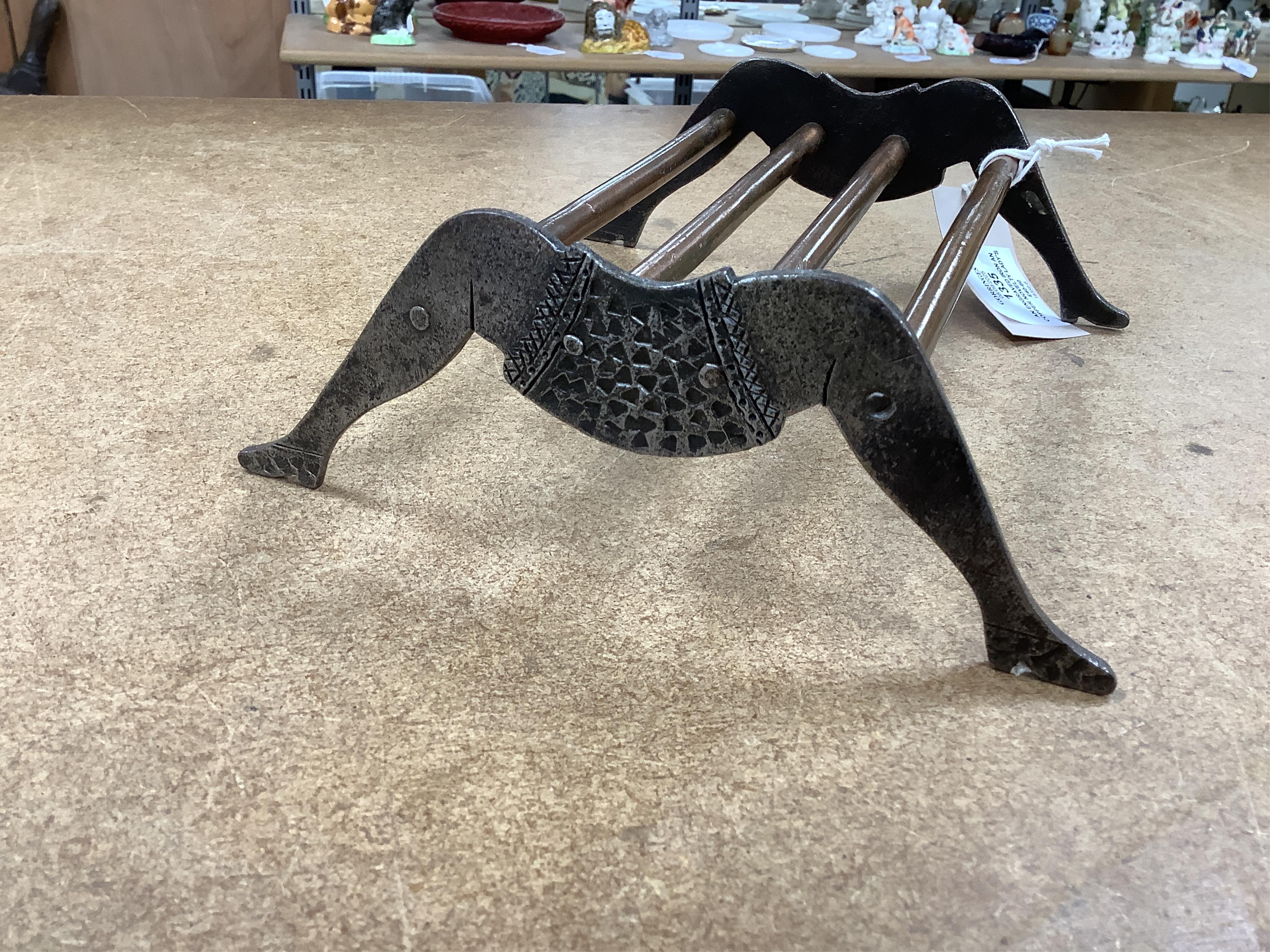 An engraved iron and copper novelty lady's legs stand, 21cm wide